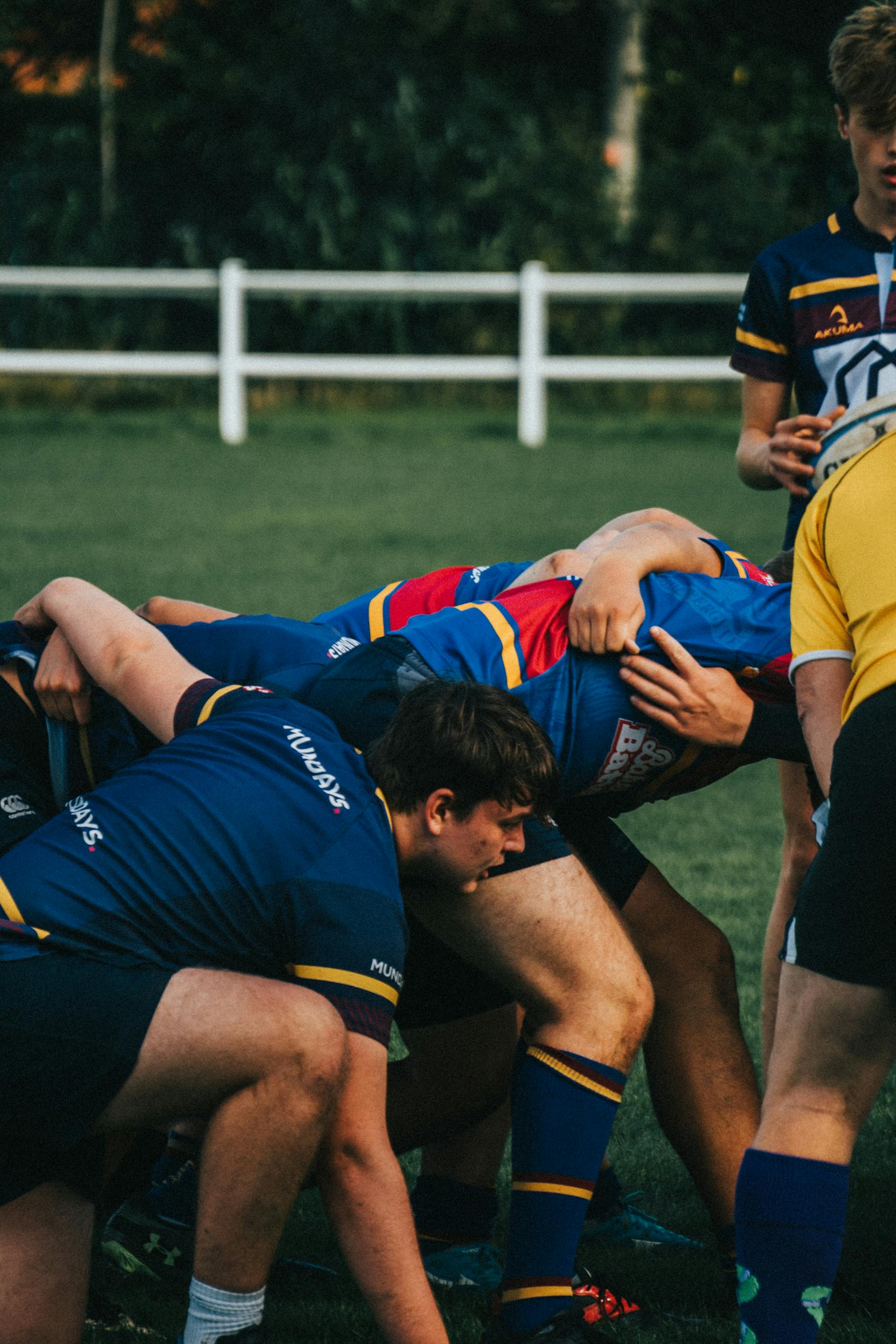 Rugby players in a scrummage formation during a competitive outdoor match.